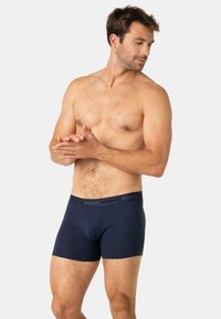 Boxer-briefs bleu marine en tissu doux. Équipés d'une taille avec le logo "Eminence". Coupe ajustée sans coutures visibles.