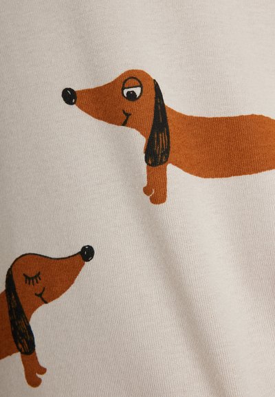 Δύο καφέ σκίτσο σκύλοι Dachshund με μαύρα αυτιά και μύτες σε ανοιχτό μπεζ ύφασμα φόντο.