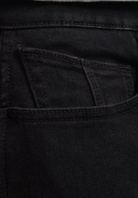 Sorte denim jeans med en lille frontlomme, synlig syning og en ensartet tekstur. Stoffet ser slidstærkt og tætsiddende ud.