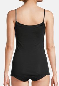 Black camisole with thin straps, made from a smooth, stretchy fabric. It features a straight back and a fitted shape, reaching the hips.