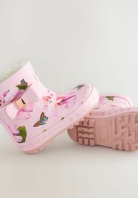 Bottes de pluie en caoutchouc roses avec des motifs floraux, des designs de papillons et un accent nœud. Semelle à grip texturé pour une meilleure adhérence. Fini lisse et enduit.