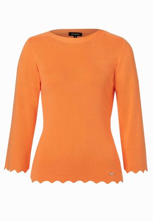 Pull en tricot orange à côtes avec des manches trois-quarts, un ourlet festonné et un petit logo métallique près du bas à gauche.