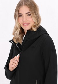 Črna zip-up jakna z kapuco, gladka tekstura, subtilna logotip na prsih ter kontrastna notranja podloga z detajlom z vrvico.