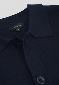 Granatowa dzianinowa koszulka polo z płaskim kołnierzykiem, z zapięciem na guziki i gładką teksturą. Metka z napisem "LANCERTO" i rozmiarem "M."