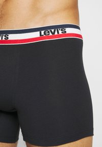 Schwarze Stretch-Baumwoll-Boxershorts mit einem mehrfarbigen Bund, der rote, weiße und marineblaue Akzente sowie das "Levi's"-Logo aufweist.