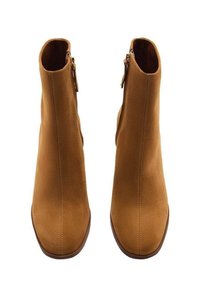 Une paire de bottines en daim marron avec fermetures éclair latérales, bouts carrés arrondis et petits talons, vues en angle de dessus et de face sur fond blanc.
