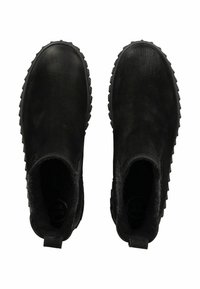 Botas negras hasta el tobillo con un exterior de cuero texturizado, punta redondeada y paneles laterales elásticos. Suela de goma gruesa con un patrón de banda de rodadura robusto.