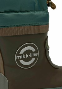 Botte en caoutchouc marron avec une tige en textile turquoise. Présente une bande marron texturée, un logo sur le côté et une fermeture par cordon de serrage en haut.