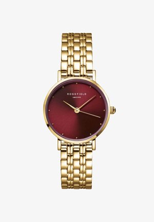 Zlatni sat s burgundskom brojčanicom, s jednostavnim oznakama sati, teksturiranom površinom i metalnom narukvicom. Logo se nalazi na 12 sati.