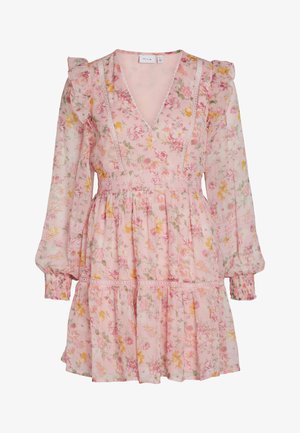 Lillelille rohelise ja roosa lillelise kleidiga, mis on valmistatud läbipaistvast roosast kangast, millel on volangiga varrukad. Omab V-kaela, pitsist äärist, vormitud taljet ja kihilist seelikut, millel on erinevad väikesed lillemustrit.