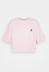 Różowa krótka koszulka z bawełny z krótkimi rękawami. Posiada małe czarne logo Kangol na piersi. Miękka tekstura, prosty design.