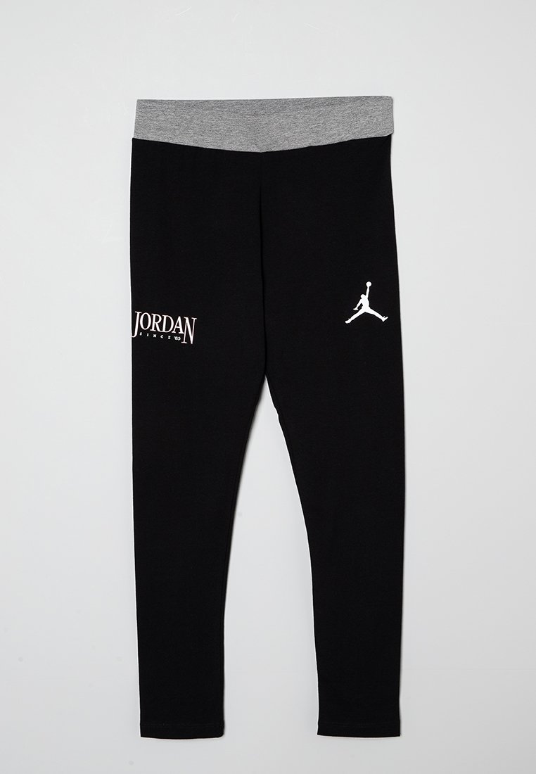 Leggings neri realizzati in tessuto morbido con una vita grigia. Presentano il testo e il logo bianco "JORDAN" sulla gamba sinistra. Design aderente.