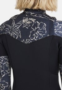 Wetsuit featuring a dark floral patterned upper section and solid black lower body. Made from stretch material with seam details.