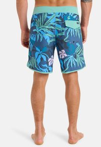 Blåa och gröna badbyxor med tropiskt mönster har en mintgrön midja och bakficka med lock.