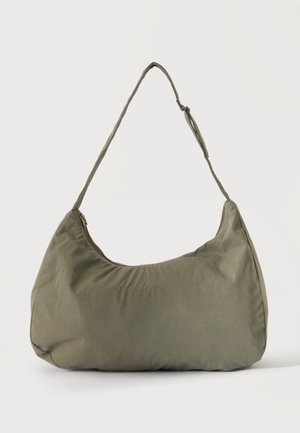 Sac à épaule en tissu doux vert olive avec fermeture éclair et bandoulière réglable sur un fond uni clair.