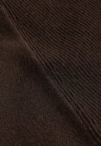 Brown textured fabric with a ribbed pattern, featuring a soft, plush surface and a rich, deep color.