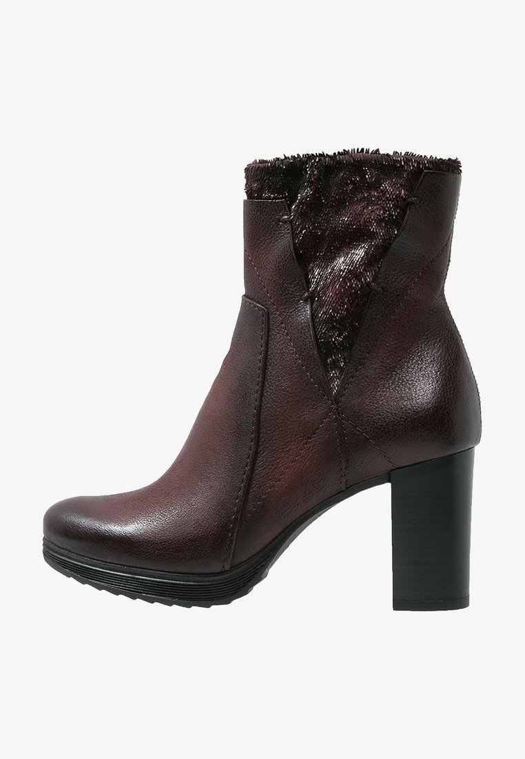 Bottine en cuir marron foncé avec talon bloc noir et bordure en fourrure, coutures latérales décoratives et semelle texturée.