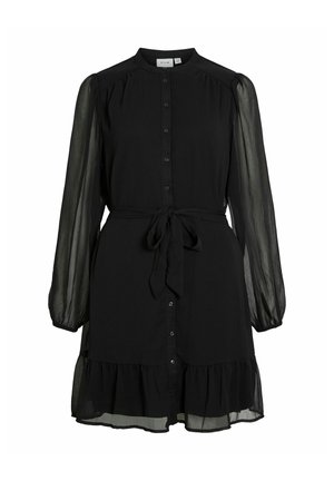 Robe noire avec un devant à boutons, de longues manches transparentes, un ourlet frangé et une ceinture à nouer à la taille. Fabriquée en tissu léger.