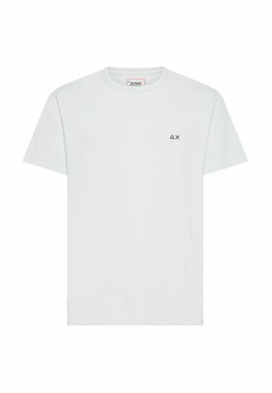 T-shirt bianca a maniche corte con scollo a girocollo e piccoli simboli neri a forma di triangolo e X sul petto a sinistra.