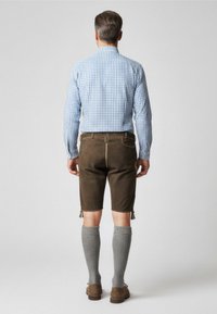 Checkered blue shirt, brown leather shorts, gray knee-length socks, with tassels at shorts' hem, functional stitching and accents.