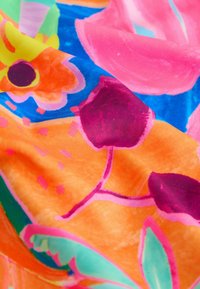 Élénk színű szövet virág- és absztrakt mintákkal rózsaszínben, narancsban, kékben és zöldben. Simább textúrájú, látványos, körvonalozott mintákkal.