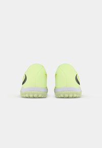 Chaussures de sport néon jaunes avec des accents noirs, talon arrondi, semelle extérieure texturée et matériau synthétique. Présente un design à profil bas.