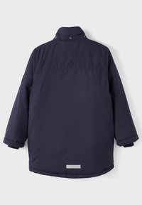 Veste d'hiver matelassée bleu marine avec manches longues, col montant à boutons-pression et une petite bande réfléchissante près du bas du dos.