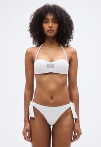 Σετ λευκό μπικίνι με τοπ μπαντό με τύπωμα λογότυπου και προσαρμόσιμα εσώρουχα μπικίνι με δέσιμο στο πλάι. Λεία υφή, λιτός σχεδιασμός.