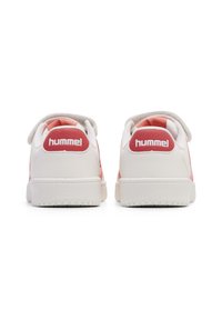 Białe trampki z różowymi akcentami, gładki materiał syntetyczny, okrągły nosek, wyściełany kołnierz oraz logo "hummel" na pięcie.
