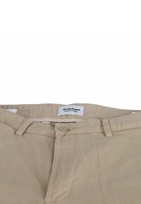 Beige cotton pants with a button closure and belt loops, featuring a smooth texture and a label reading "JACK & JONES PANTS STUDIO."