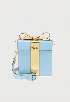 Blaue Handtasche in Form einer Geschenkbox mit einem goldfarbenen, metallischen vertikalen Streifen und Schleife, ausgestattet mit einem abnehmbaren Schulterriemen und Moschino-Logo.