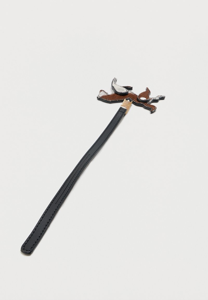 Cintura in pelle nera con una piccola toppa cucita a forma di cane marrone e bianco attaccata vicino alla fibbia.