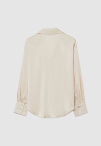 Silk long-sleeve shirt in soft beige with a classic collar, buttoned cuffs, and a curved hem. Smooth texture with a subtle sheen.