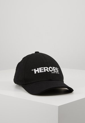 Black baseball cap with white embroidered text "HEROES" and "DAVID BOWIE" on the front, displayed on a white surface.