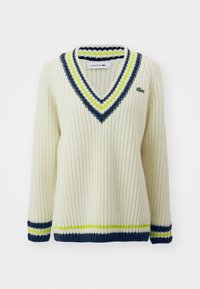 Cremfarbener Strickpullover mit V-Ausschnitt, der navyblaue, limettengrüne und weiße Streifen aufweist. Mit kleinem Lacoste-Logo auf der Brust.
