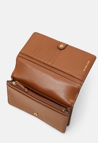 Ruskea nahkalompakko, jossa on napsauttamalla suljettava kansi, sisäiset korttipaikat ja vetoketjullinen osasto kolikoita tai pieniä esineitä varten. Kultaista metallin koristetta.