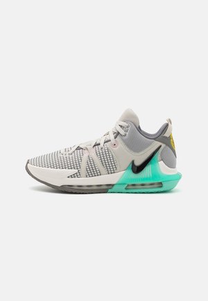 Urheilukenkä, jossa on hengittävä harmaa verkkopinta, ruudukkomuotoilu, vaaleanpunaiset yksityiskohdat ja turkoosi läpikuultava pohja, jossa on musta Nike-logo.