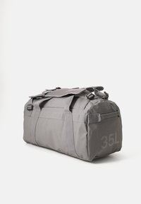 Szürke, nylon anyagból készült sporttáska, dupla fogantyúkkal, levehető vállpánttal, az oldalán pedig nyomtatott "35L" felirattal.