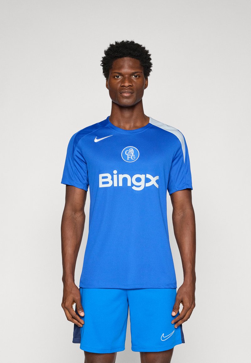 Blå Nike fodboldtrøje med korte ærmer, der har et rundt logo og teksten "Bingx". Kombineret med matchende blå shorts. Glat tekstur.