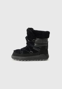 Bottines noires avec un extérieur duveteux, des accents en cuir et des lacets ajustables, sur un fond blanc uni.