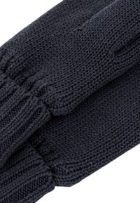 Guanti neri a maglia realizzati in filato morbido, con polsini a coste e una texture liscia, inquadratura ravvicinata dei dettagli di cucitura.