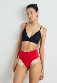 Spanx SPANXSUPERSMOOTH™ UNDIE-TECTABLE® THONG - Tangice - red