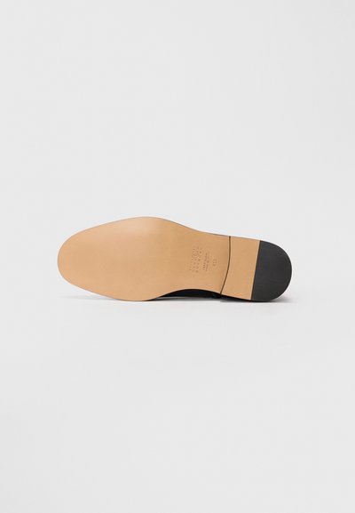 Leder-sohlen Kleiderschuh von der Sohle aus betrachtet, zeigt eine glatte, hellbraune Ledersohle mit schwarzem Absatz sowie eingestempelten Größen- und Materialdetails.