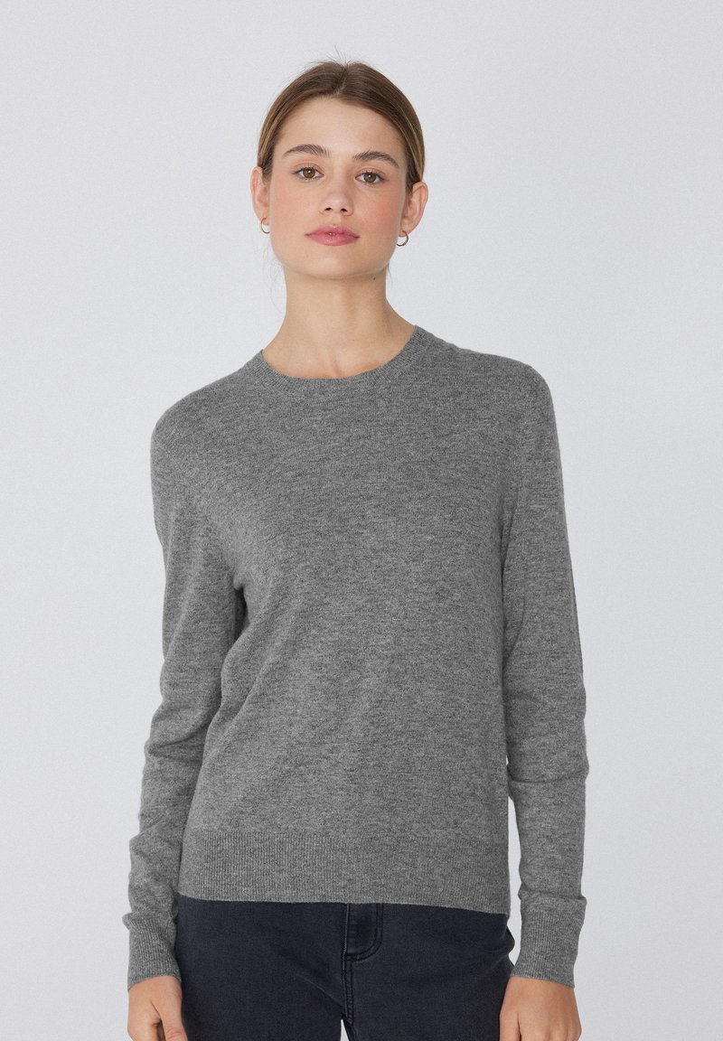 Grauer Strickpullover mit Rundhalsausschnitt, langen Ärmeln und geripptem Saum. Weicher Stoff und klassischer Schnitt, geeignet für legere Anlässe.