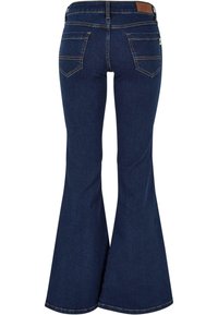 Uitlopende denim jeans in donker indigo, met gestikte achterzakken, een gladde afwerking en een licht beschadigde tailleband.