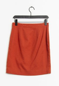 Falda lápiz de mezcla de lana roja con una cinturilla texturizada, corte recto y dos bolsillos frontales. Cuelga de una percha de plástico negra.