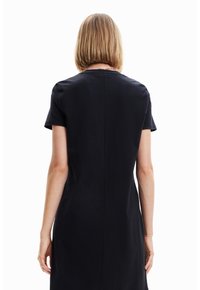 Krótka czarna sukienka z krótkim rękawem, o prostym kroju, gładkiej fakturze i detalach szwów na plecach. Minimalistyczny design, bez widocznych ozdobników.