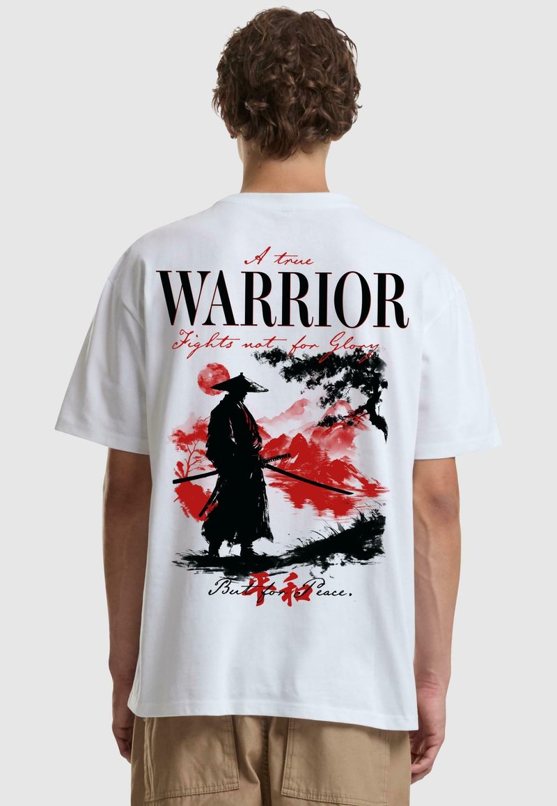 T-shirt bianco in cotone con una grande grafica nera e rossa di un samurai e il testo "Un vero GUERRIERO" e "Combatte non per la Gloria."