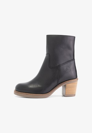 Bottine en cuir noir à bout rond, avec un talon bloc empilé beige et un logo embossé sur le côté, présentée de profil sur fond blanc.