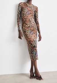 Robe à manches longues en imprimé léopard avec détail découpé, silhouette près du corps et longueur mi-mollet. Tissu doux avec un dégradé de couleurs.